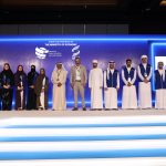 Group photo of event staff and participants on stage at a UAE Internal Auditors Association conference under the Ministry of Economy